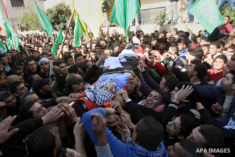 Mourners carry the body of 17-year-old Palestinian teenager Omam Dwekat, who was shot dead by Israeli troops the day before, during his funeral in the West Bank village of Baita, near of Nablus, on Dec. 30, 2014. Dwekat...