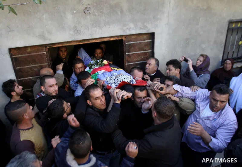 Mourners carry the body of 17-year-old Palestinian teenager Omam Dwekat, who was shot dead by Israeli troops the day before, during his funeral in the West Bank village of Baita, near of Nablus, on Dec. 30, 2014. Dwekat...