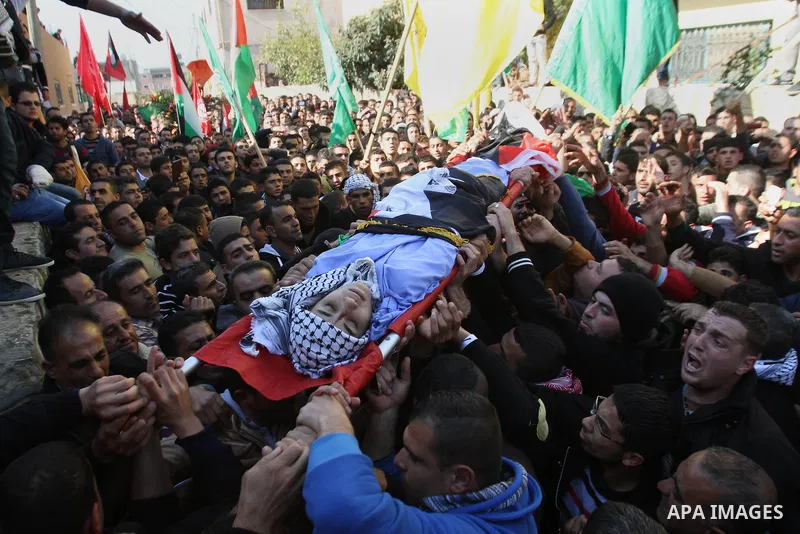 Mourners carry the body of 17-year-old Palestinian teenager Omam Dwekat, who was shot dead by Israeli troops the day before, during his funeral in the West Bank village of Baita, near of Nablus, on Dec. 30, 2014. Dwekat...
