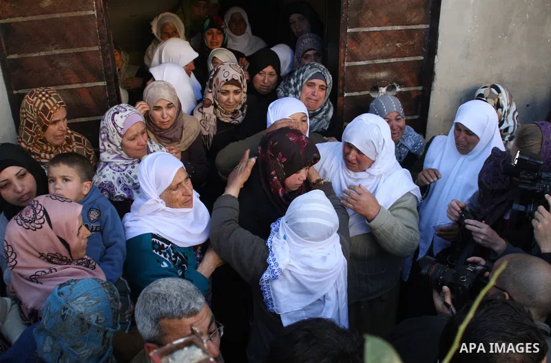 Relatives of 17-year-old Palestinian teenager Omam Dwekat, who was shot dead by Israeli troops the day before, mourn for him during the funeral in the West Bank village of Baita, near of Nablus, on Dec. 30, 2014. Dwekat...