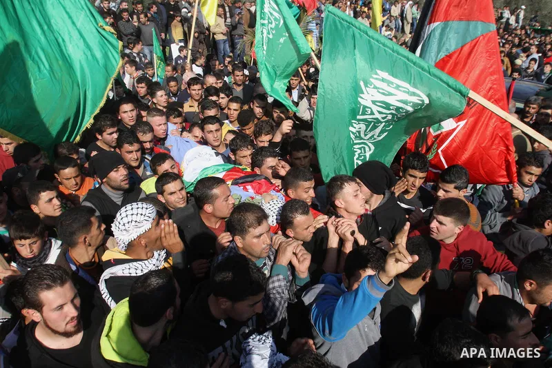 Mourners carry the body of 17-year-old Palestinian teenager Omam Dwekat, who was shot dead by Israeli troops the day before, during his funeral in the West Bank village of Baita, near of Nablus, on Dec. 30, 2014. Dwekat...