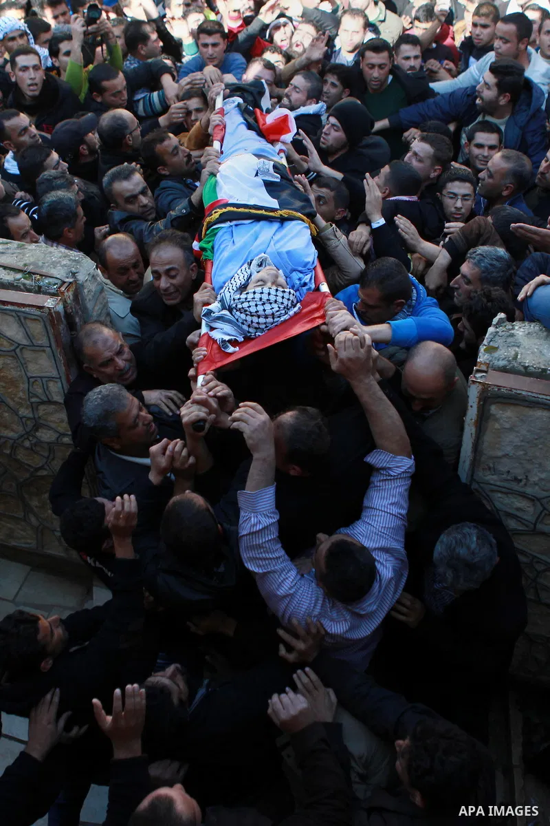 Mourners carry the body of 17-year-old Palestinian teenager Omam Dwekat, who was shot dead by Israeli troops the day before, during his funeral in the West Bank village of Baita, near of Nablus, on Dec. 30, 2014. Dwekat...