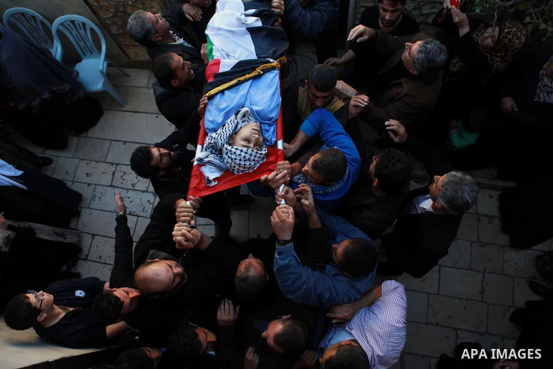 Mourners carry the body of 17-year-old Palestinian teenager Omam Dwekat, who was shot dead by Israeli troops the day before, during his funeral in the West Bank village of Baita, near of Nablus, on Dec. 30, 2014. Dwekat...