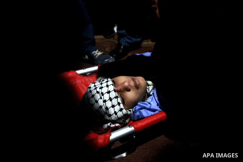 The body of 17-year-old Palestinian teenager Omam Dwekat, who was shot dead by Israeli troops the day before, during his funeral in the West Bank village of Baita, near of Nablus, on Dec. 30, 2014. Dwekat was killed duri...