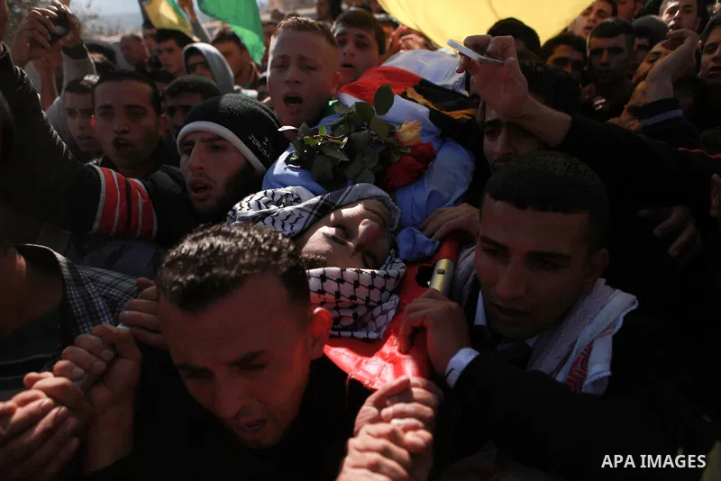 Mourners carry the body of 17-year-old Palestinian teenager Omam Dwekat, who was shot dead by Israeli troops the day before, during his funeral in the West Bank village of Baita, near of Nablus, on Dec. 30, 2014. Dwekat...
