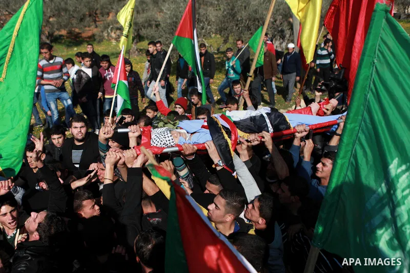 Mourners carry the body of 17-year-old Palestinian teenager Omam Dwekat, who was shot dead by Israeli troops the day before, during his funeral in the West Bank village of Baita, near of Nablus, on Dec. 30, 2014. Dwekat...