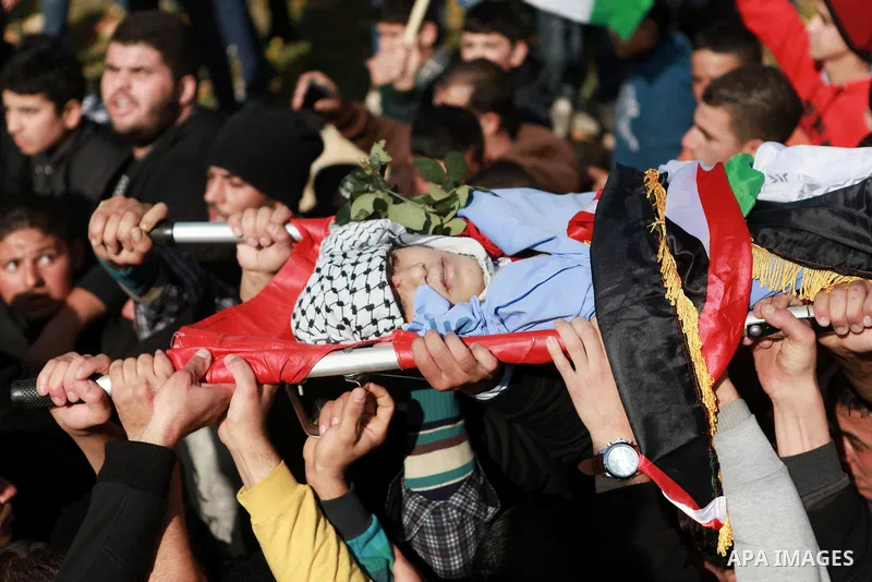 Mourners carry the body of 17-year-old Palestinian teenager Omam Dwekat, who was shot dead by Israeli troops the day before, during his funeral in the West Bank village of Baita, near of Nablus, on Dec. 30, 2014. Dwekat...
