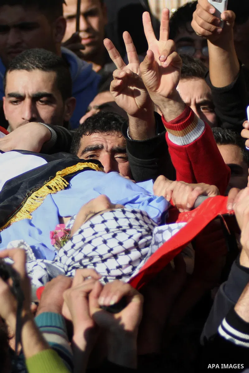 Mourners carry the body of 17-year-old Palestinian teenager Omam Dwekat, who was shot dead by Israeli troops the day before, during his funeral in the West Bank village of Baita, near of Nablus, on Dec. 30, 2014. Dwekat...