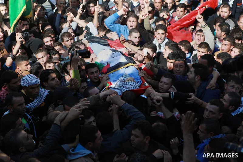 Mourners carry the body of 17-year-old Palestinian teenager Omam Dwekat, who was shot dead by Israeli troops the day before, during his funeral in the West Bank village of Baita, near of Nablus, on Dec. 30, 2014. Dwekat...