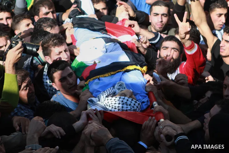 Mourners carry the body of 17-year-old Palestinian teenager Omam Dwekat, who was shot dead by Israeli troops the day before, during his funeral in the West Bank village of Baita, near of Nablus, on Dec. 30, 2014. Dwekat...