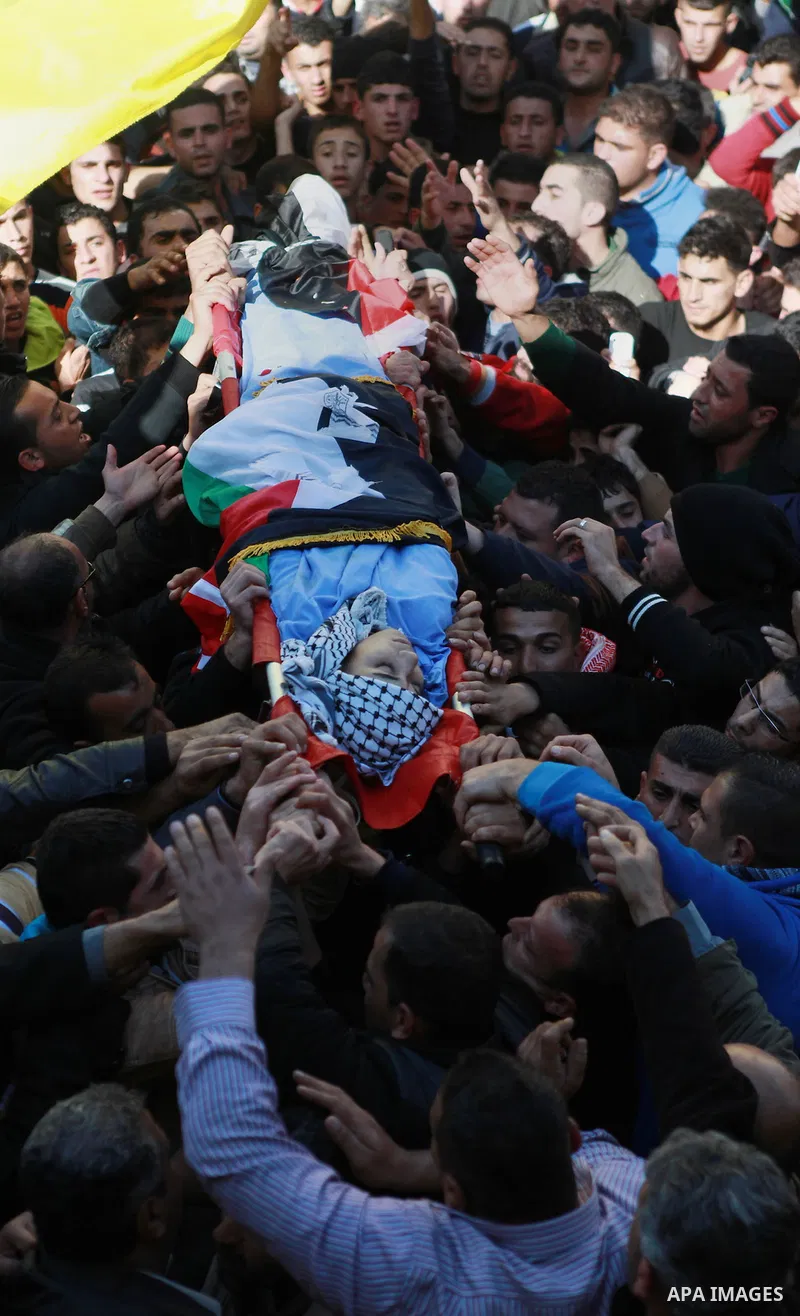 Mourners carry the body of 17-year-old Palestinian teenager Omam Dwekat, who was shot dead by Israeli troops the day before, during his funeral in the West Bank village of Baita, near of Nablus, on Dec. 30, 2014. Dwekat...