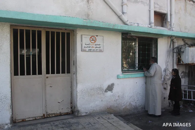 Palestinians stand outside a closed clinic during the strike of the employees of former Palestinian government in Gaza Strip to demand for pay their salaries, in Gaza city on December 31, 2014. The Palestinian unity gove...