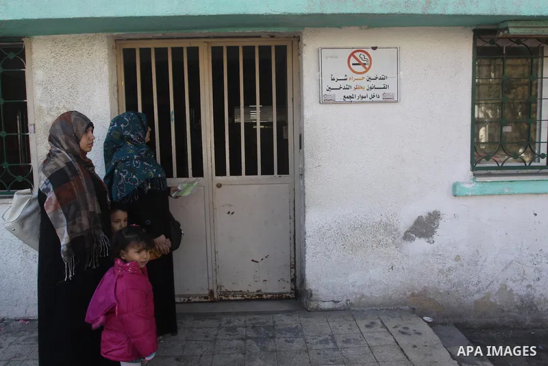 Palestinians stand outside a closed clinic during the strike of the employees of former Palestinian government in Gaza Strip to demand for pay their salaries, in Gaza city on December 31, 2014. The Palestinian unity gove...