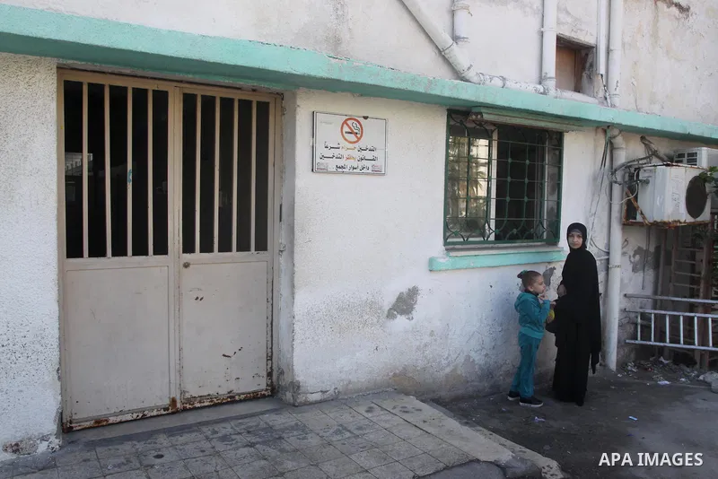 Palestinians stand outside a closed clinic during the strike of the employees of former Palestinian government in Gaza Strip to demand for pay their salaries, in Gaza city on December 31, 2014. The Palestinian unity gove...