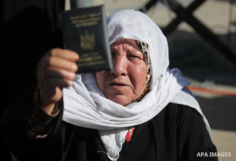 A Palestinian woman holds her passport during a protest demanding for the opening of Rafah crossing border in front of the headquarters of the Council of Ministers in Gaza city, on December 31, 2014. Photo by Ashraf Amra