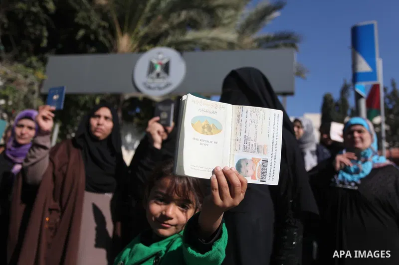 Palestinian women hold their passports during a protest demanding for the opening of Rafah crossing border in front of the headquarters of the Council of Ministers in Gaza city, on December 31, 2014. Photo by Ashraf Amra