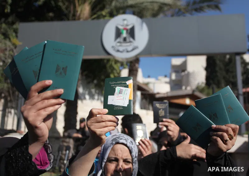 Palestinian women hold their passports during a protest demanding for the opening of Rafah crossing border in front of the headquarters of the Council of Ministers in Gaza city, on December 31, 2014. Photo by Ashraf Amra