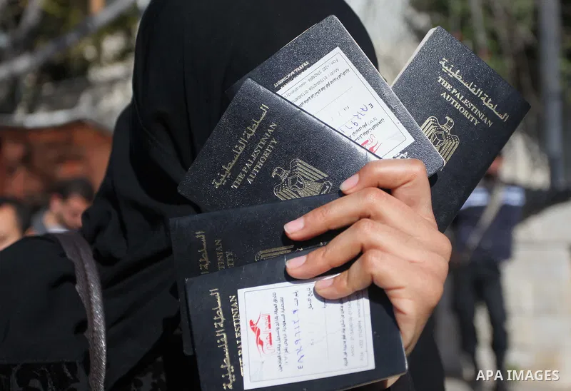 Palestinian women hold their passports during a protest demanding for the opening of Rafah crossing border in front of the headquarters of the Council of Ministers in Gaza city, on December 31, 2014. Photo by Ashraf Amra