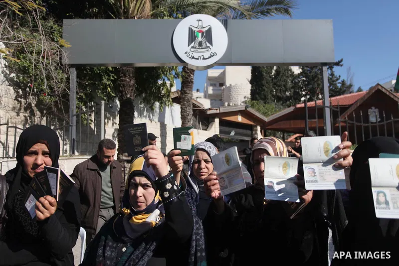 Palestinian women hold their passports during a protest demanding for the opening of Rafah crossing border in front of the headquarters of the Council of Ministers in Gaza city, on December 31, 2014. Photo by Ashraf Amra