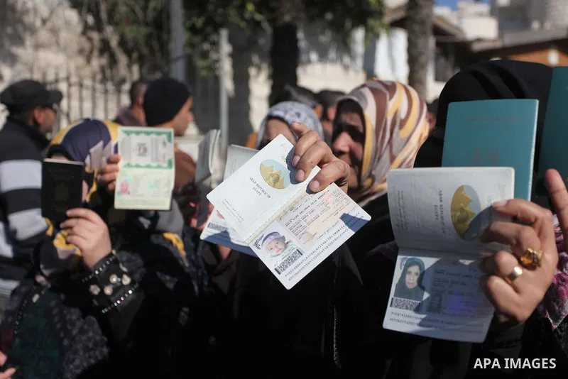 Palestinian women hold their passports during a protest demanding for the opening of Rafah crossing border in front of the headquarters of the Council of Ministers in Gaza city, on December 31, 2014. Photo by Ashraf Amra