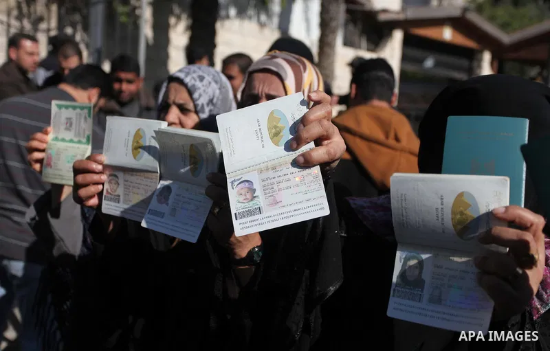 Palestinian women hold their passports during a protest demanding for the opening of Rafah crossing border in front of the headquarters of the Council of Ministers in Gaza city, on December 31, 2014. Photo by Ashraf Amra