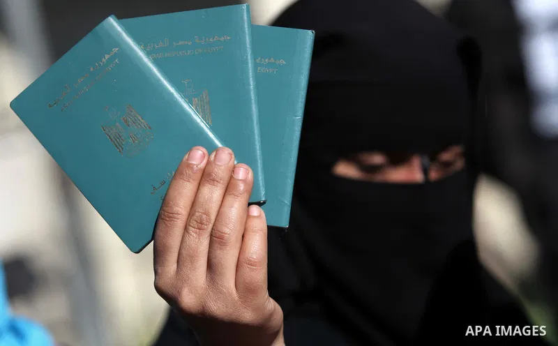 A Palestinian woman holds her passport during a protest demanding for the opening of Rafah crossing border in front of the headquarters of the Council of Ministers in Gaza city, on December 31, 2014. Photo by Ashraf Amra