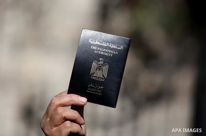 A Palestinian woman holds her passport during a protest demanding for the opening of Rafah crossing border in front of the headquarters of the Council of Ministers in Gaza city, on December 31, 2014. Photo by Ashraf Amra