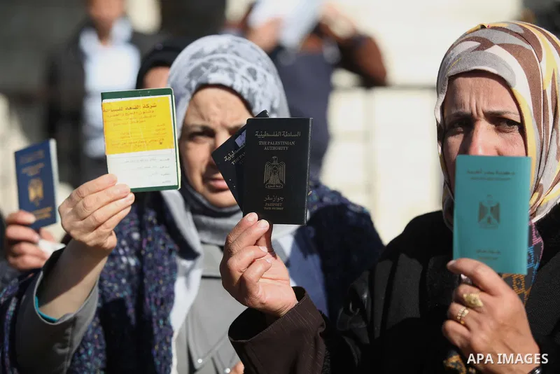 Palestinian women hold their passports during a protest demanding for the opening of Rafah crossing border in front of the headquarters of the Council of Ministers in Gaza city, on December 31, 2014. Photo by Ashraf Amra