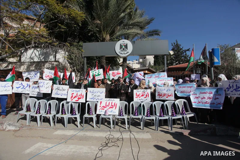 Palestinians hold posters during a rally organized as part of a general of the employees of former Palestinian government in Gaza Strip to demand for pay their salaries in front of the headquarters of the Council of Mini...