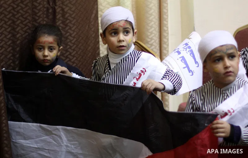 Palestinian children hold placards during a ceremony organised in solidarity with al-Aqsa mosque and against the Israeli restriction on Jerusalem, in Gaza city on December 31, 2014. Photo by Mohammed Asad