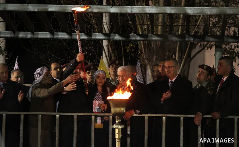 Palestinian President Mahmoud Abbas lights a torch during a rally marking the 50th anniversary of the founding of the Fatah movement, in the West Bank city of Ramallah December 31, 2014. Abbas signed on to 20 internation...