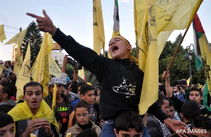 Palestinian Fatah supporter shout slogans during a gathering to celebrate the fiftieth anniversary of the start of the Fatah movement, in Gaza city on December 31, 2014. The Fatah movement was founded by the late iconic...