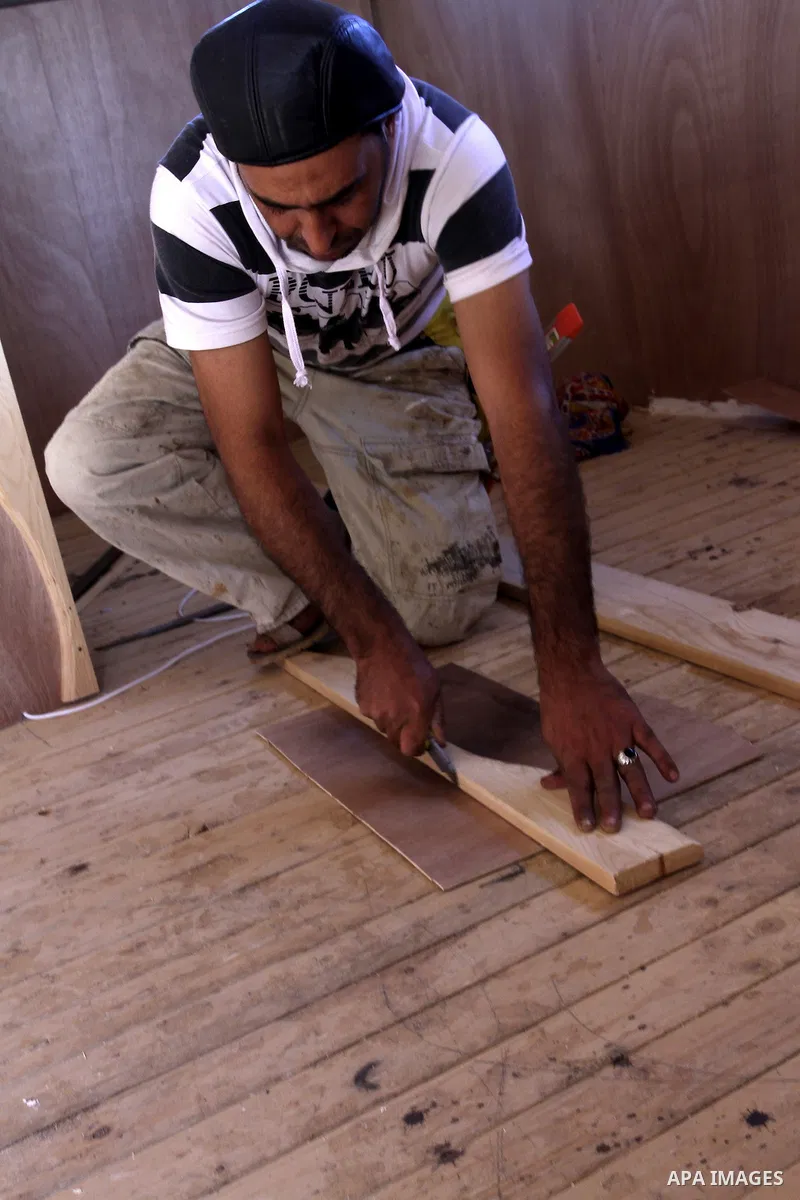Palestinian carpenter Ibrahim Dokhan, 36, works using wood to rebuild a house, which was damaged during the recent Israeli offensive on Gaza Strip, in Rafah in the southern Gaza Strip, December 31, 2014. Because of the s...