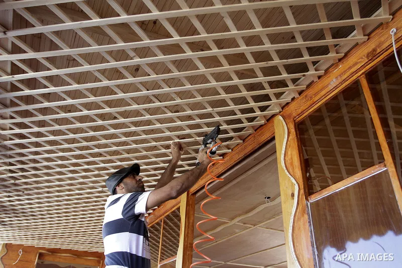 Palestinian carpenter Ibrahim Dokhan, 36, works using wood to rebuild a house, which was damaged during the recent Israeli offensive on Gaza Strip, in Rafah in the southern Gaza Strip, December 31, 2014. Because of the s...