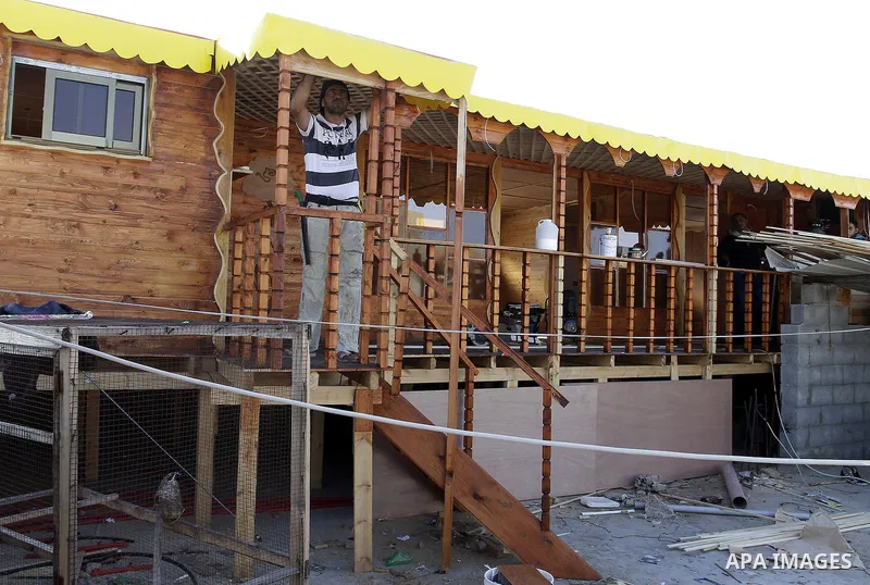 Palestinian carpenter Ibrahim Dokhan, 36, works using wood to rebuild a house, which was damaged during the recent Israeli offensive on Gaza Strip, in Rafah in the southern Gaza Strip, December 31, 2014. Because of the s...