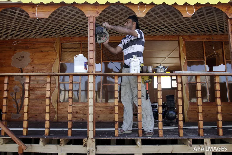 Palestinian carpenter Ibrahim Dokhan, 36, works using wood to rebuild a house, which was damaged during the recent Israeli offensive on Gaza Strip, in Rafah in the southern Gaza Strip, December 31, 2014. Because of the s...