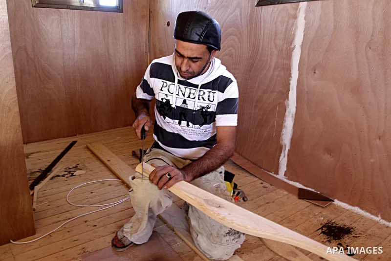 Palestinian carpenter Ibrahim Dokhan, 36, works using wood to rebuild a house, which was damaged during the recent Israeli offensive on Gaza Strip, in Rafah in the southern Gaza Strip, December 31, 2014. Because of the s...