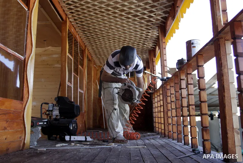 Palestinian carpenter Ibrahim Dokhan, 36, works using wood to rebuild a house, which was damaged during the recent Israeli offensive on Gaza Strip, in Rafah in the southern Gaza Strip, December 31, 2014. Because of the s...