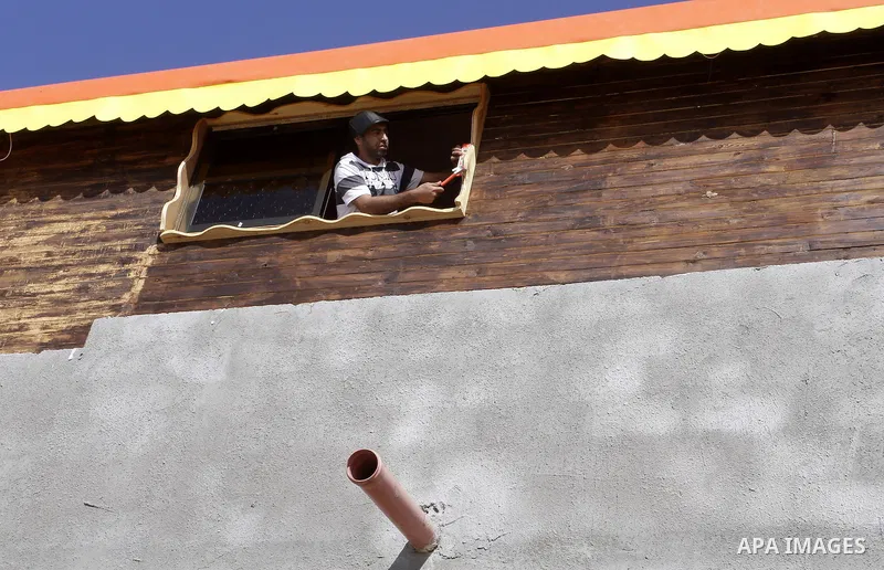 Palestinian carpenter Ibrahim Dokhan, 36, works using wood to rebuild a house, which was damaged during the recent Israeli offensive on Gaza Strip, in Rafah in the southern Gaza Strip, December 31, 2014. Because of the s...