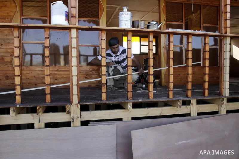 Palestinian carpenter Ibrahim Dokhan, 36, works using wood to rebuild a house, which was damaged during the recent Israeli offensive on Gaza Strip, in Rafah in the southern Gaza Strip, December 31, 2014. Because of the s...
