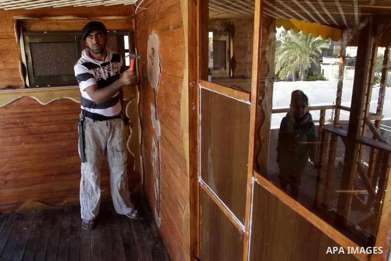 Palestinian carpenter Ibrahim Dokhan, 36, works using wood to rebuild a house, which was damaged during the recent Israeli offensive on Gaza Strip, in Rafah in the southern Gaza Strip, December 31, 2014. Because of the s...