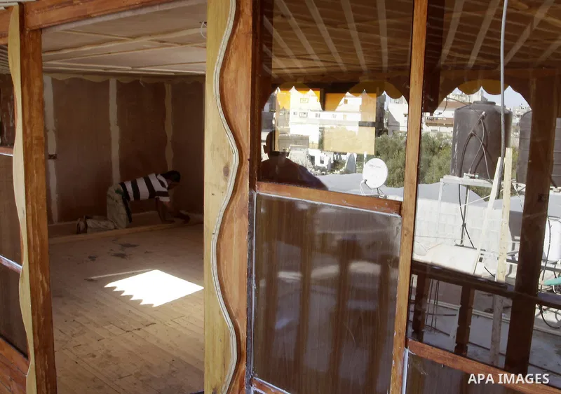 Palestinian carpenter Ibrahim Dokhan, 36, works using wood to rebuild a house, which was damaged during the recent Israeli offensive on Gaza Strip, in Rafah in the southern Gaza Strip, December 31, 2014. Because of the s...
