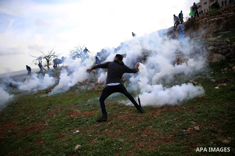 A Palestinian protester uses a sling shot to throw stones at Israeli security forces during clashes near Israel's Ofer prison, near the West Bank city of Ramallah January 2, 2015. Photo by Shadi Hatem