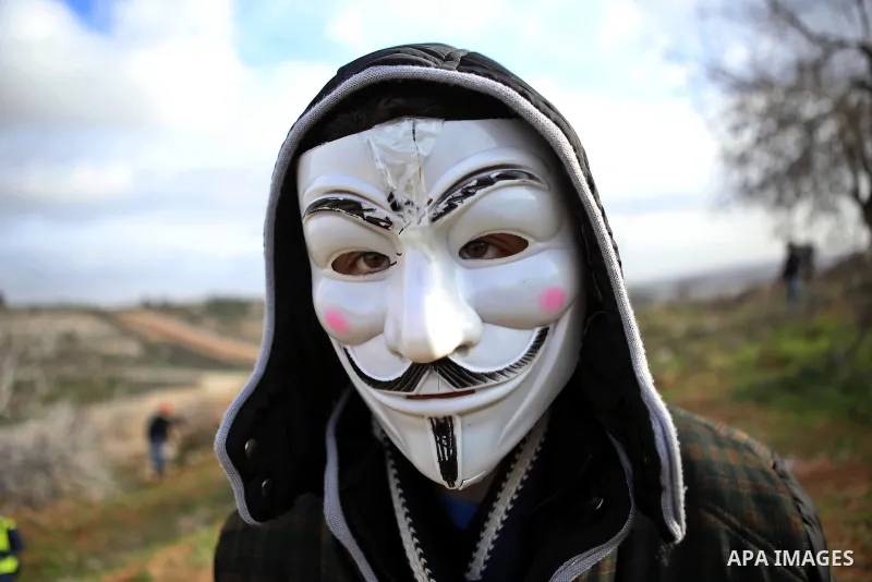 A masked Palestinian protester looks on during clashes with Israeli security forces near Israel's Ofer prison, near the West Bank city of Ramallah January 2, 2015. Photo by Shadi Hatem