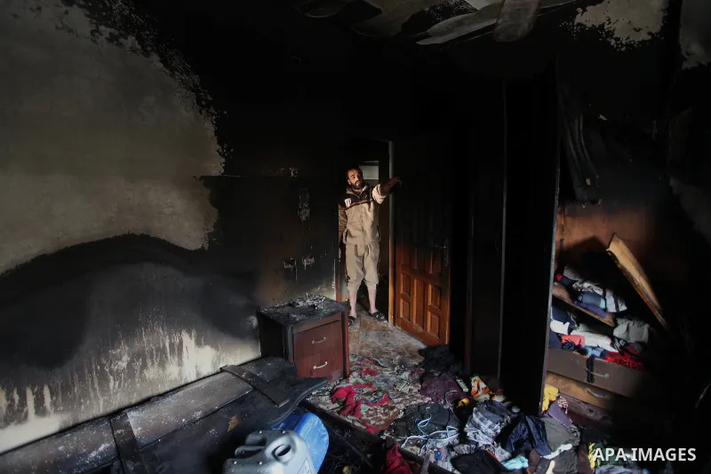 A Palestinian man looks at a burnt bedroom where two teen relatives died when fire broke out due to an electrical malfunction in the backup power system in their home in Beach refugee camp in Gaza City January 4, 2015. P...