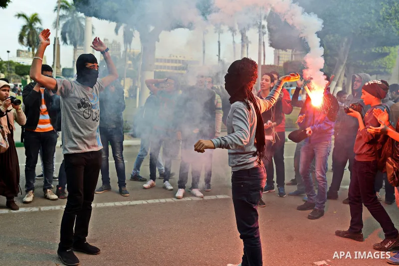 Egyptian students who support ousted President Mohamed Morsi and the Muslim Brotherhood light up a flare as they demonstrate against the military rule, at the Cairo University in Cairo on January 5, 2015. Cairo criminal...