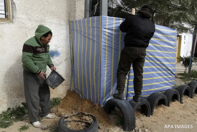 Palestinians set a plastic shelter outside their house during a heavy winter storm in Rafah in the southern Gaza Strip on January 7, 2015. A storm buffeted the Middle East with blizzards, rain and strong winds on Wednesd...