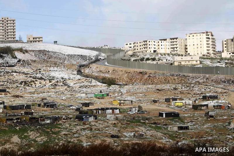 Snowfall is seen around a section of the controversial Israeli barrier that runs along the Shuafat refugee camp in the West Bank near Jerusalem January 8, 2015. A storm buffeted the Middle East with blizzards, rain and s...