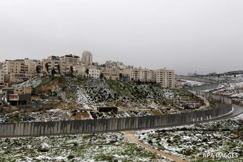 Snowfall is seen around a section of the controversial Israeli barrier that runs along the Shuafat refugee camp in the West Bank near Jerusalem January 8, 2015. A storm buffeted the Middle East with blizzards, rain and s...