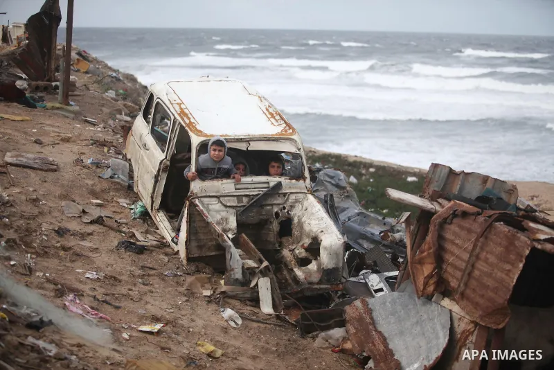 Palestinian children play in a car off the coast of Gaza Strip during a heavy winter storm, in Gaza city January 8, 2015. A storm buffeted the Middle East with blizzards, rain and strong winds on Wednesday, keeping peopl...